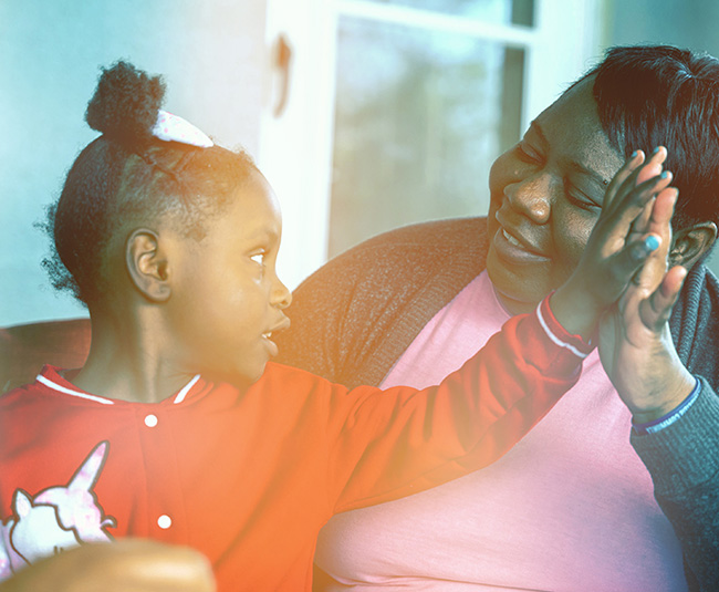 A mother and young daughter high-fiving